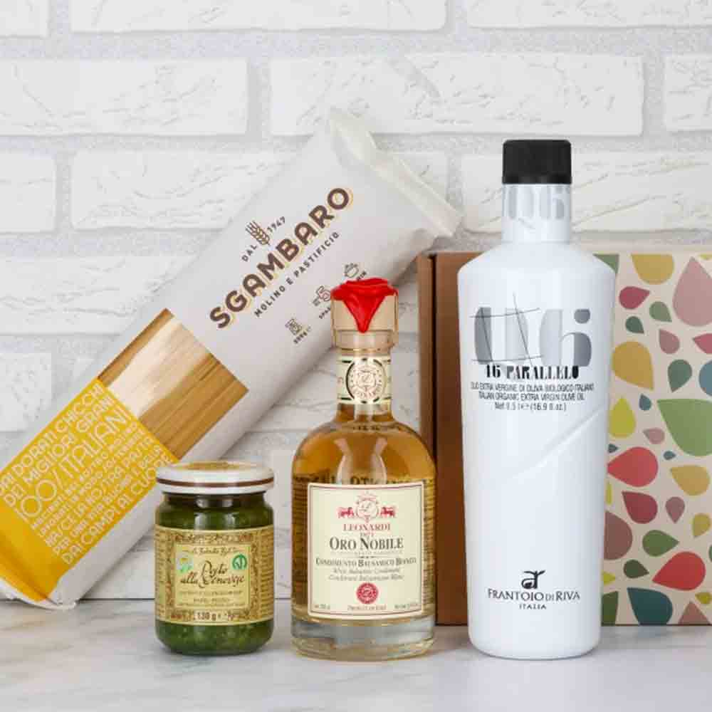 Olivenöl, Essig, Pasta, Pesto, Geschenkbox vor weißer Wand.