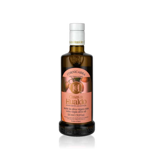 Flasche Casas de Hualdo Cornicabra Olivenöl auf schwarzem Hintergrund.