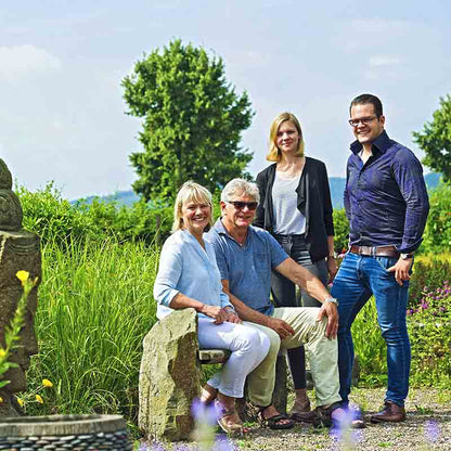 Vier Personen im Garten stehend.