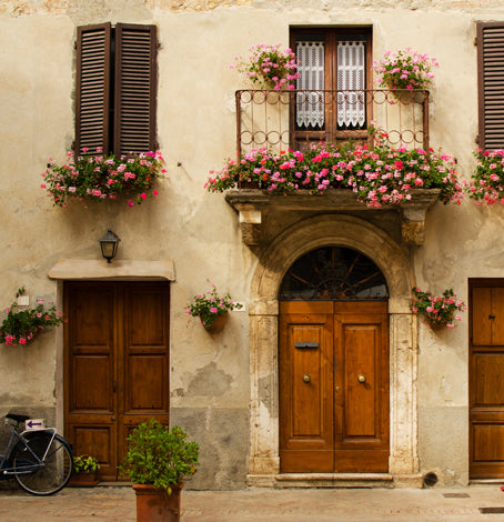 Italienische Hausfassade mit Blumen.