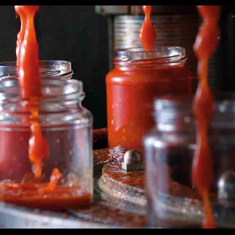 Tomatensauce wird in Gläser abgefüllt.