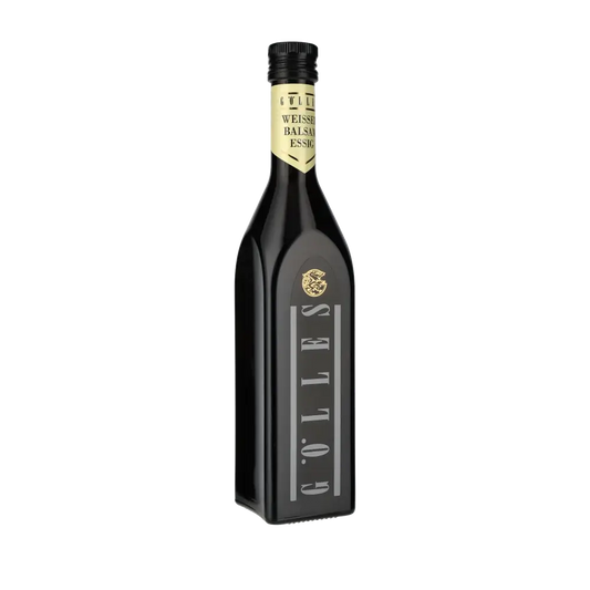 Gölles Weißer Balsamico Essig Flasche vor schwarzem Hintergrund.