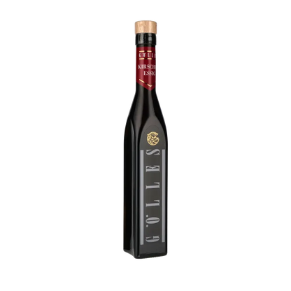 Gölles Kirschenessig Flasche vor schwarzem Hintergrund.