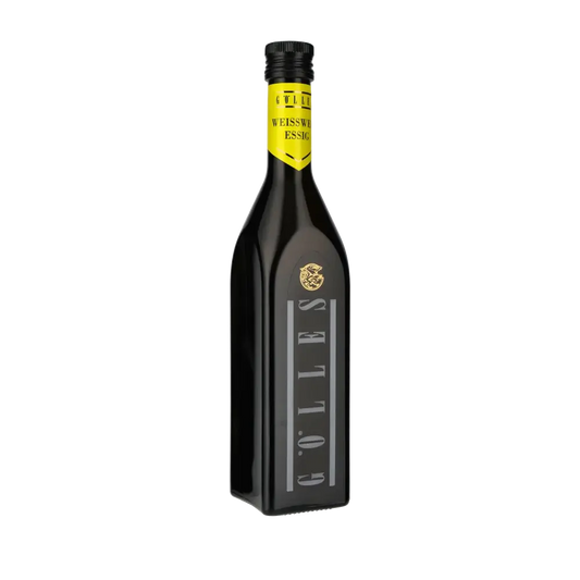 Gölles Weißweinessig Flasche auf schwarzem Hintergrund.
