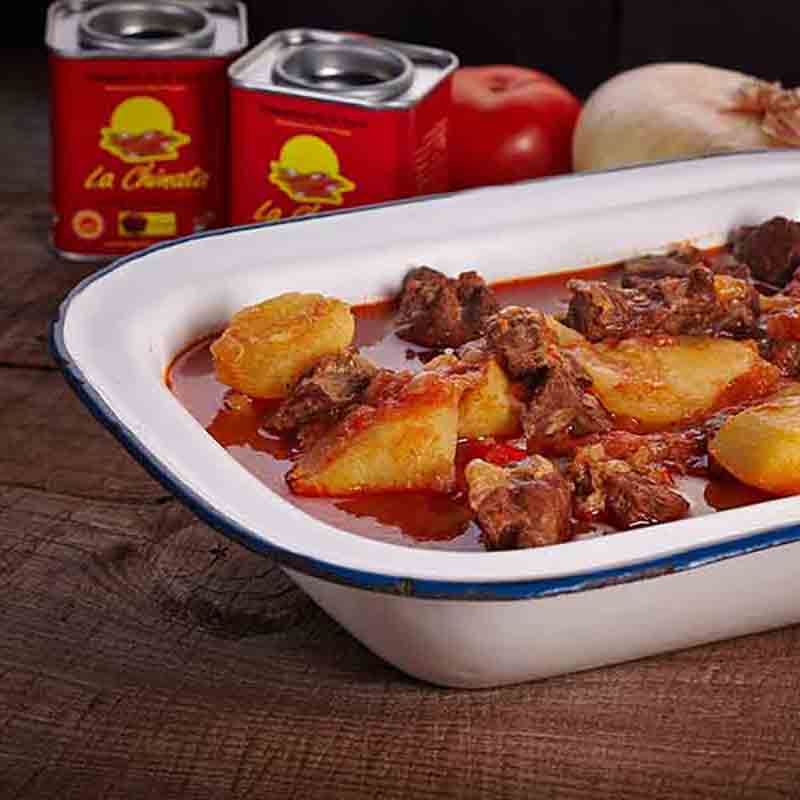 Feinkostgericht mit Fleisch, Kartoffeln, La Chinata Dosen im Hintergrund.
