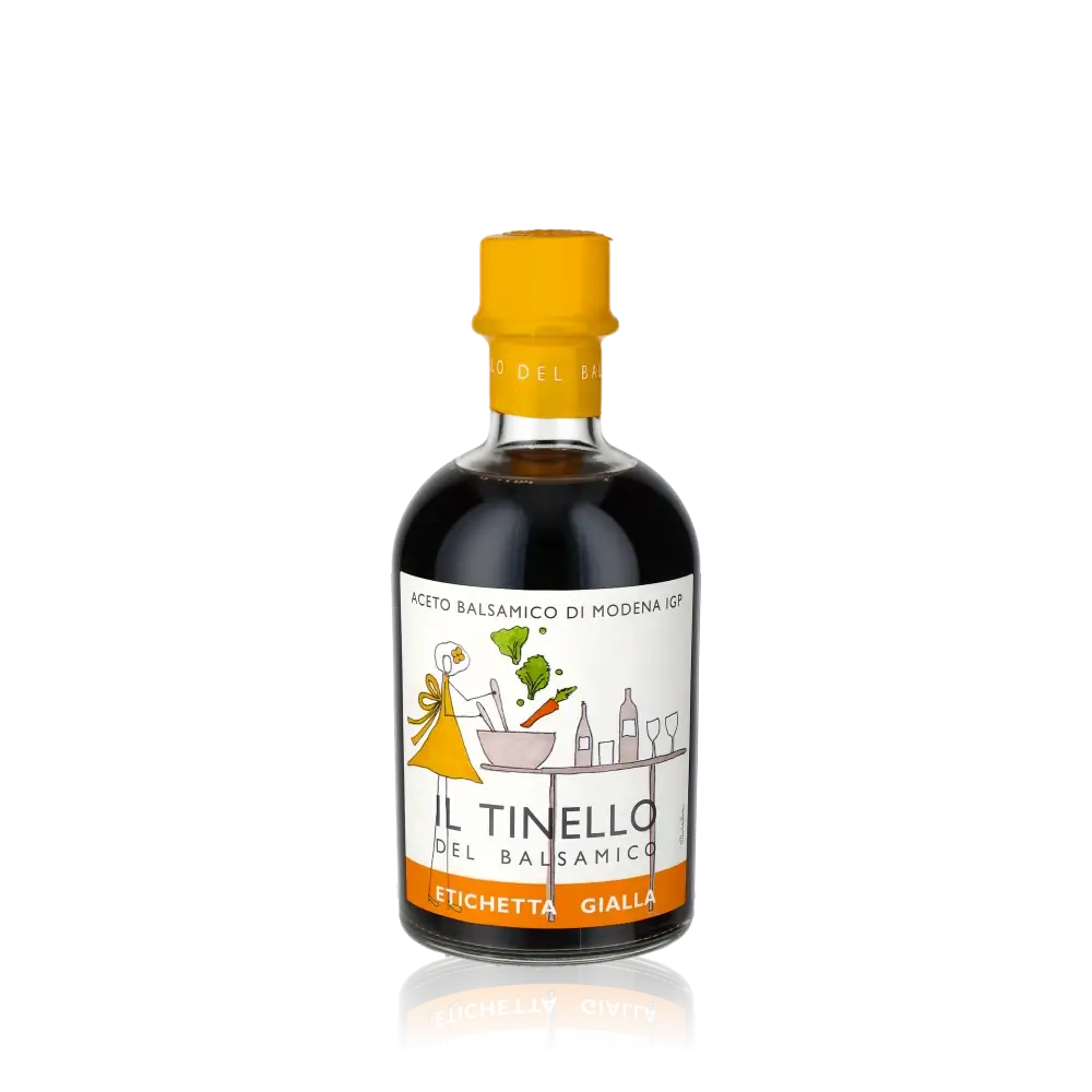 Balsamico-Essigflasche Il Tinello Gelbes Etikett vor schwarzem Hintergrund.