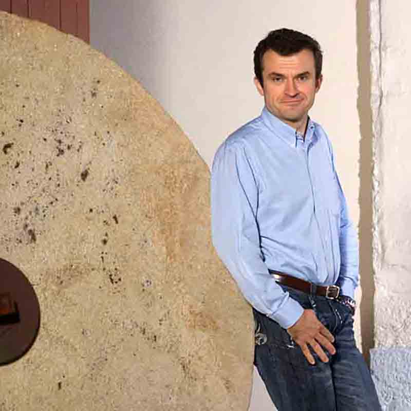 Marc Désarménien lehnt in seiner Manufaktur in Frankreich am Mühlstein.