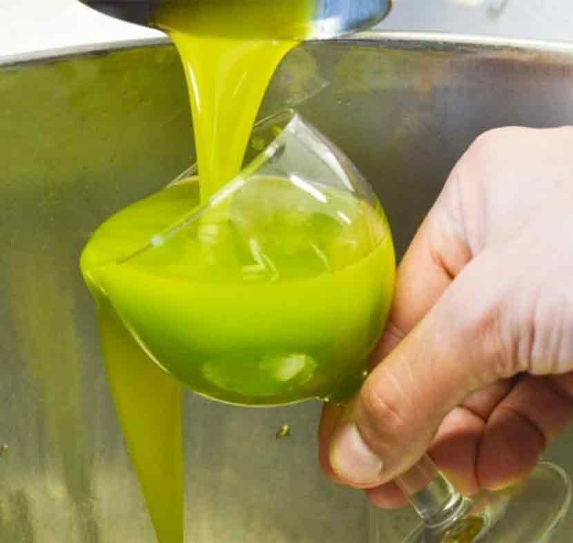 Olivenöl wird in ein Glas gegossen.