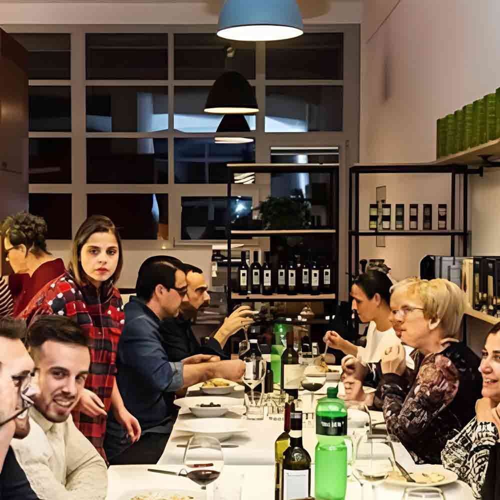 Menschen essen gemeinsam an einem Tisch mit Wein.