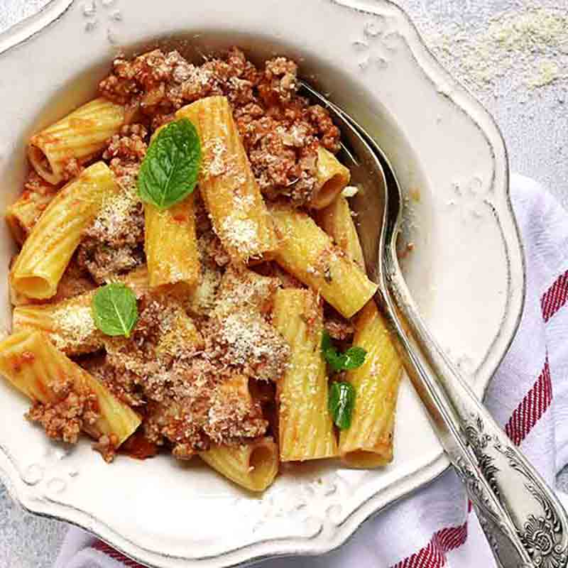 Rigatoni mit Fleischsauce und Parmesan.