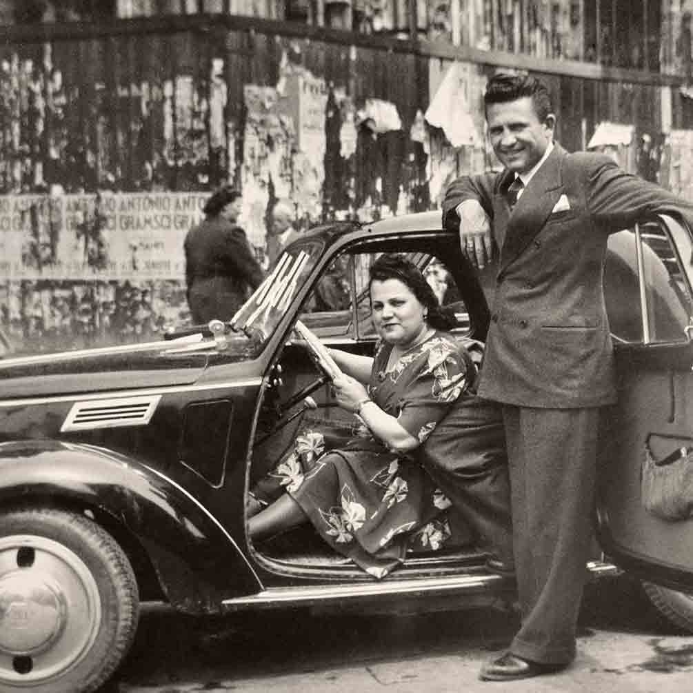 Mann und Frau neben Auto.