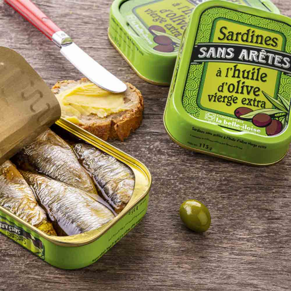 Sardinen in Olivenöl, Brot, Messer, grüne Olivendose, Olive.