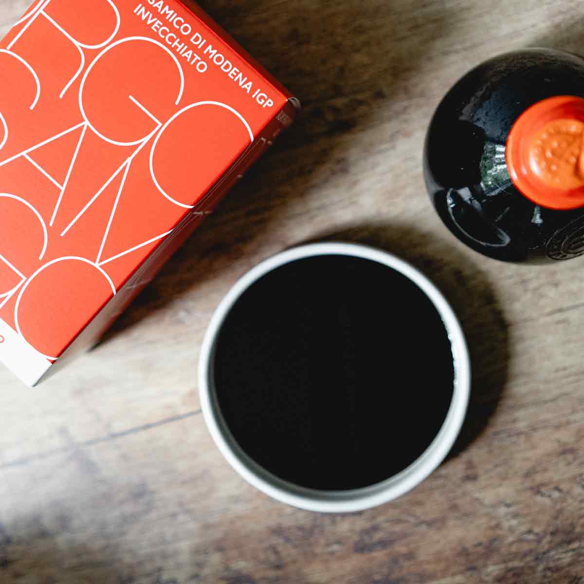 Borgo Balsamico Essigflasche und Verpackung auf Holztisch.