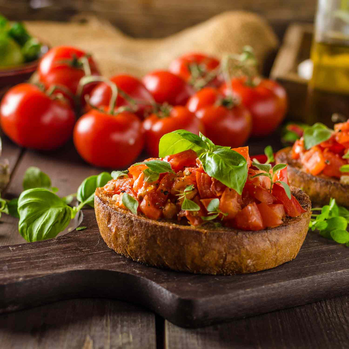 Bruschetta mit Tomaten, Basilikum, Olivenöl auf Holzbrett.