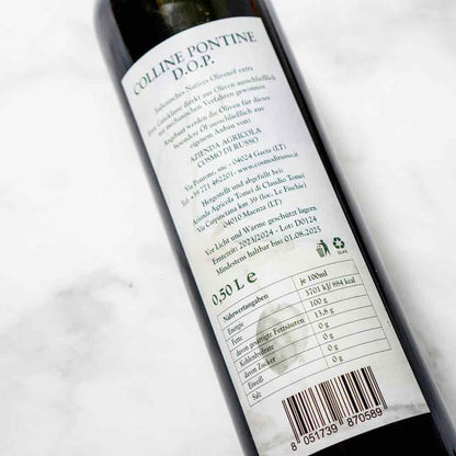 Rückseite einer Olivenölflasche mit Etikett und Informationen.