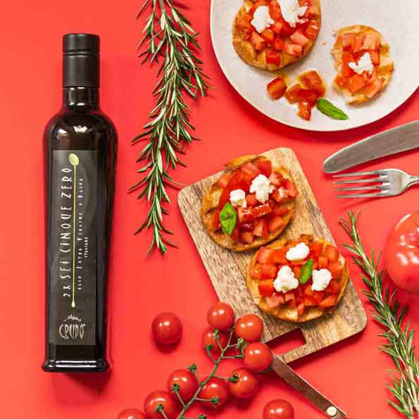 Flasche Crudo Olivenöl, Bruschetta, Tomaten, Rosmarin, Gabel, Messer.