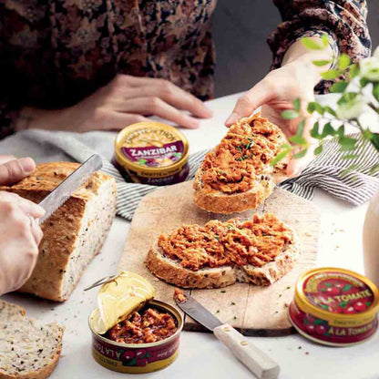 Personen genießen Brot mit Zanzibar Thunfisch aus Dosen.