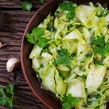Gurkensalat mit Apfelessig und Rapsöl auf Holztisch.