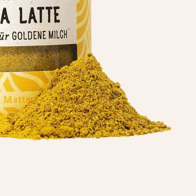 Kurkuma-Latte-Pulver mit Kurkuma-Haufen.